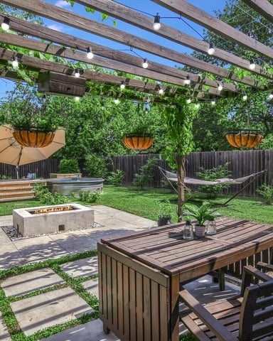 Waterfront property with fire pit, hot tub, and lounge chairs overlooking river at sunset