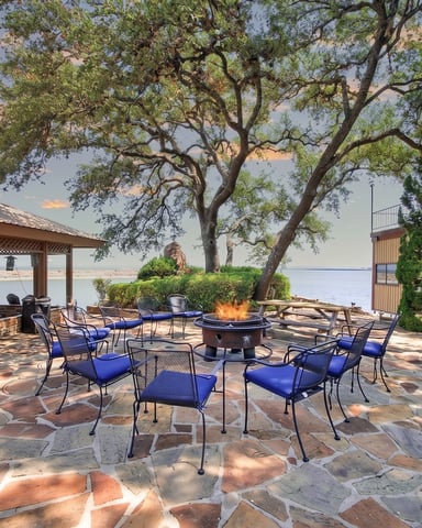 Waterfront property with pool, lounge chairs, and railing overlooking river and tree-lined hills